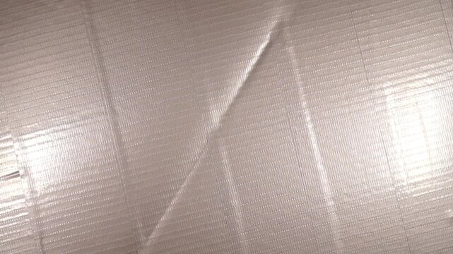 Rotation of striped silver electrical tape surface. Close-up, topview