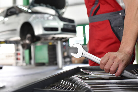 Car mechanic working in repair garage, tool box, screw wrench