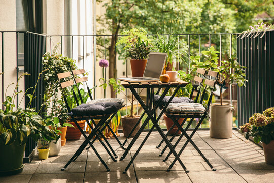 Bistro chairs and table with laptop on balcony