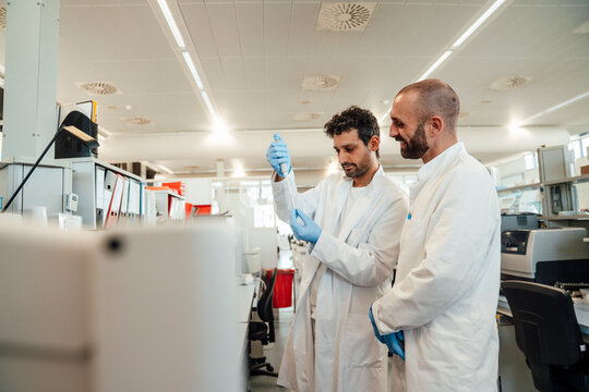 Scientists analyzing liquid sample in modern laboratory indoors