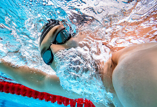 Athlete swimming freestyle underwater in a pool