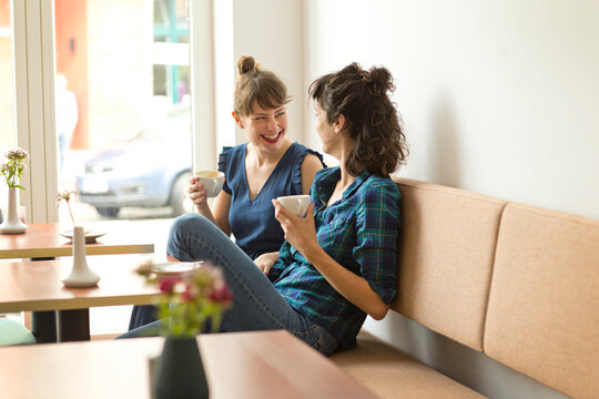 Two happy friends in a coffee shop