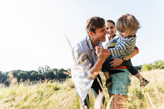 Happy family walking at the riverside on a beautiful summer day