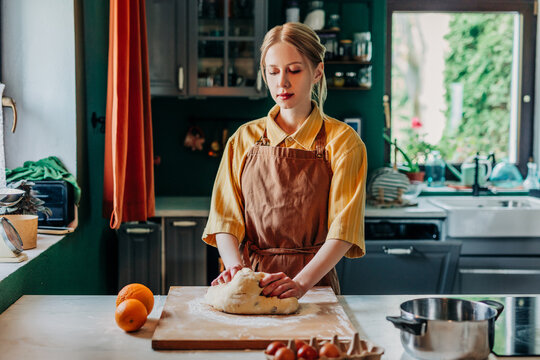 Baker kneading dough for traditional Easter bread in the kitchen