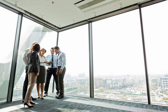 Businesspeople in office with woman using digital tablet