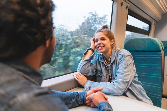 Portrait of smiling young woman travelling by train with her boyfriend, London, UK