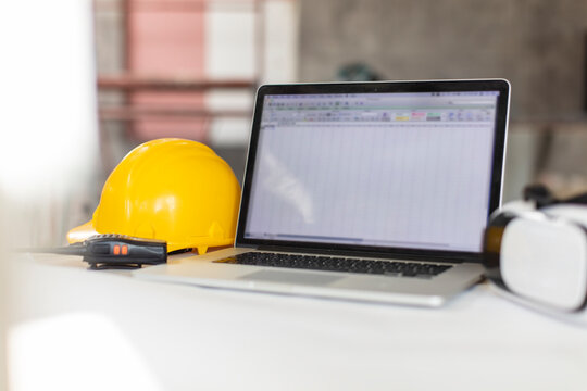 Laptop, yellow hardhat, walkie talkie and vr glasses