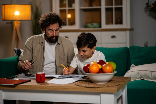 Father helping son with education homework at home