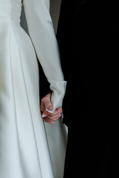 A bride holds the hand of her mother