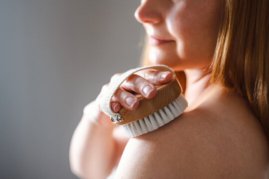 Woman dry brushing body brush, skincare wellness, self care routine