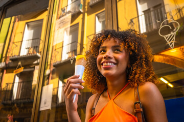 Naklejka premium Happy young woman enjoying ice cream on city street