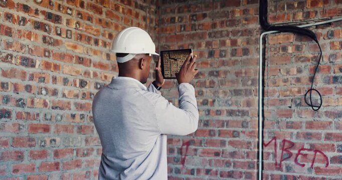 Photography, inspection and black man with tablet at construction site, compliance or review. Back, space evaluation and person with tech screen for wiring, installation or electrical line picture