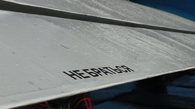 A close-up of an airplane wing with the inscription "Do not touch", metal texture and details of the aircraft structure.
