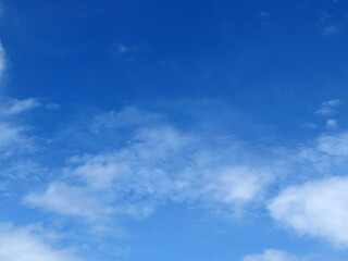 Fototapeta premium A bright blue sky background with beautiful clouds; a bottom-down, wide-angle view.