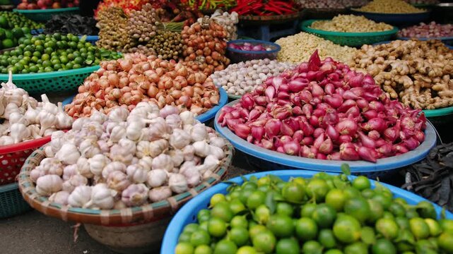 Fresh garlic, red onion, lime, and ginger for sale at a vietnam street market stall in hanoi