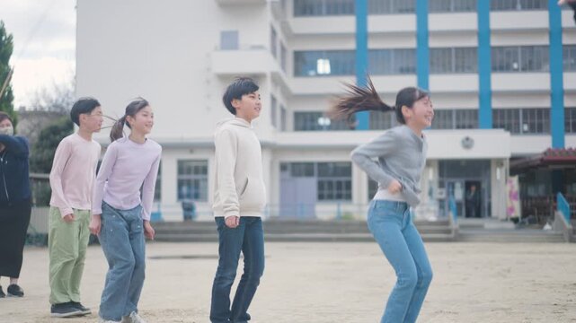 大縄跳びをする小学生