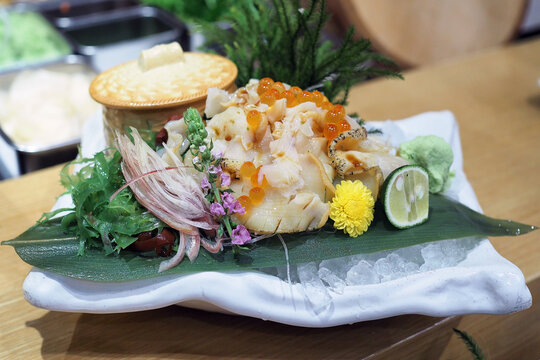 Plate of fresh sliced whelk Tsubugai sashimi (Sazae) served with salmon roe.