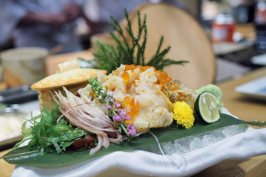 Plate of fresh sliced whelk Tsubugai sashimi (Sazae) served with salmon roe.