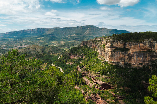Siurana canyon landscape with dramatic sandstone cliffs, winding mountain road and panoramic views of Prades Mountains in Catalonia, Spain