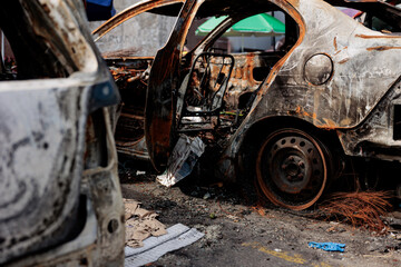 Fototapeta premium A burnt-out car as a result of Russia's missile strike against Ukraine. Car hit by shrapnel