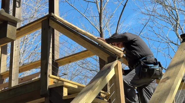 Man adding walnut logs for top stairs railings