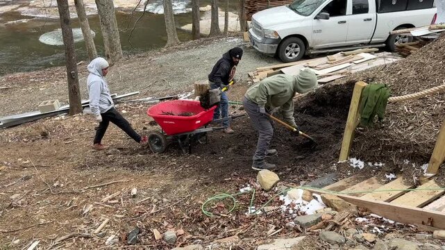 Shoveling dark rich mulch on river property