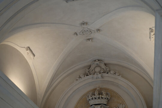 Ornate White Vaulted Ceiling with Classical Plaster Moldings and Crown Emblem
