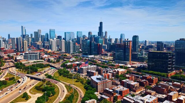 Lively scenery of modern Chicago, Illinois, USA on sunny day. Approaching American flag flapping over the cityscape. High-rises in the downtown in the backdrop.
