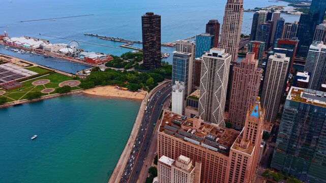 Approaching the busy highways of Lake Shore Drive along blue waterscape. Green park and Navy Pier in the scenery. Downtown Chicago, Illinois, USA.