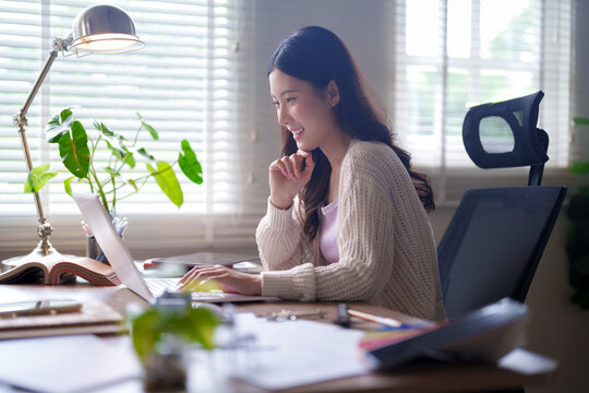 Asian woman working at ergonomic home office with modern furniture design