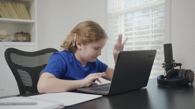 Online education and home schooler. Kid online lesson. Little student, clever kid. Child studying online in a virtual remote class on the internet at home. Excited school child using laptop computer.