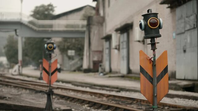 Railway signal posts beside train tracks at rural station
