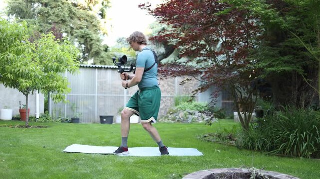 Content creator practices smooth camera movements with a gimbal in a backyard refining stability coordination and filming technique for professional video production