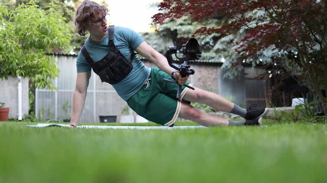 Videographer strengthens core stability with side plank exercise while holding a gimbal building endurance balance and body control for demanding filming work