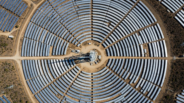 Aerial Top Down View of Concentrated Solar Power Plant with Heliostat Mirrors in Concentric Circles in Desert Landscape