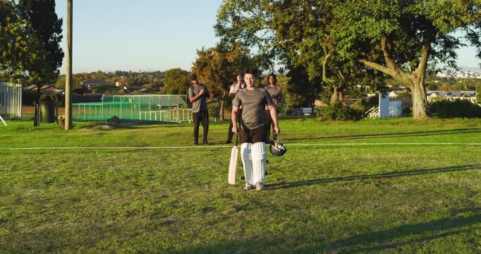 Teammates clapping, man running across park, bat, greeting partner, guarding crease