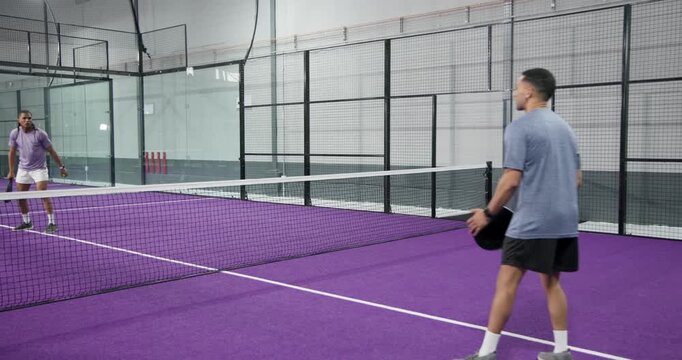 Diverse male athletes tossing ball, serving, volleying with paddles, celebrating win on court