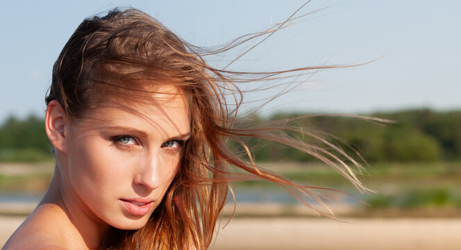 Young woman with windblown hair outdoors
