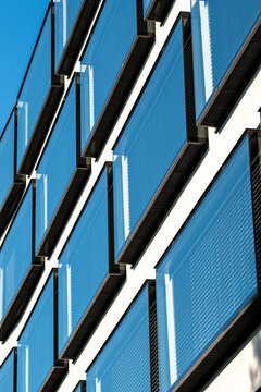 Blue glass balconies cut across a facade in diagonal lines, giving modern architecture an urban building detail of sharp exterior geometry