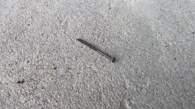 Metal screw thread on rough concrete surface close up
