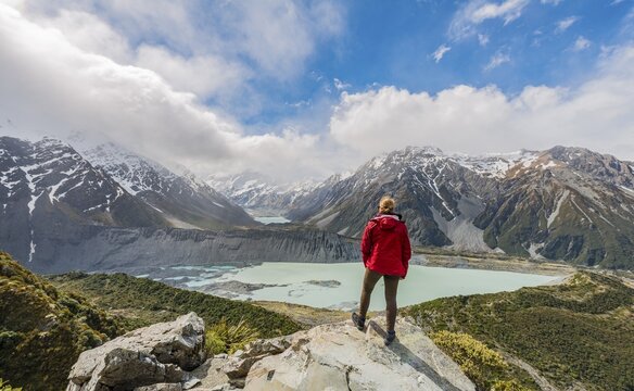 Hiker standing on rocks, view into the Hooker Valley from Sealy Tarns Track, glacial lakes Mueller Lake and Hooker Lake, Mount Cook National Park, Canterbury Region, South Island, New Zealand