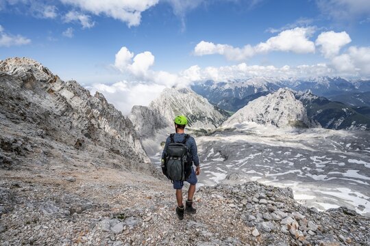 Hikers on the Hermann von Barth trail, via ferrata to the Partenkirchner Dreitorspitze, view of the Leutascher Platt with peaks &Ouml;felekopf and Musterstein and T&ouml;rlspitzen, Wetterstein range, Bavaria, Germany