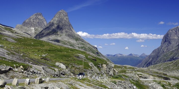 Two imposing mountain peaks rise into the blue sky, a road leads past, Trollstigen, Andalsnes, Norway