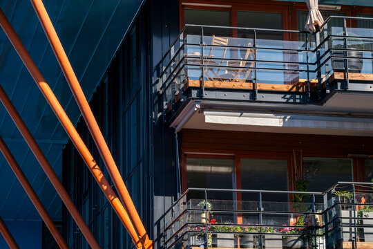 Orange lines and glass frame Oslo apartment balconies, with railings across a modern residential urban facade and exterior depth in daylight