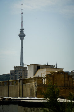 Baku TV Tower prominently rises above traditional urban architecture under a bright, clear daytime sky.