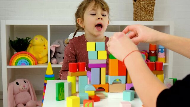A child plays with wooden blocks. Selective focus.