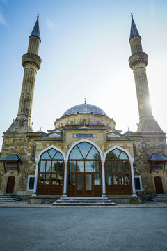 Historic Teze Pir Mosque with ornate dome, twin minarets, vibrant blue sky, Baku, Azerbaijan.
