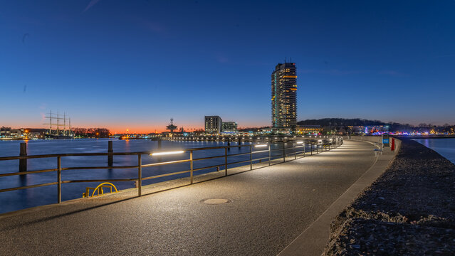 Travemuende promenade, pier under a twilight sky and  sailing ship Passat docked across the river mouth.