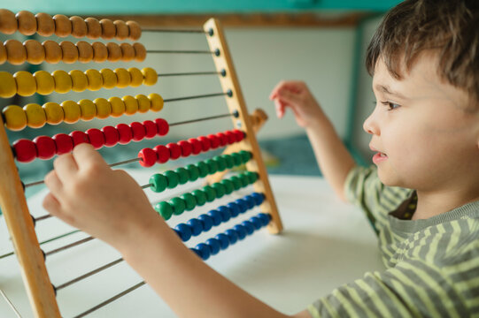 Student studying mathematics by counting on an abacus indoors