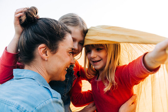 Smiling siblings with mother on weekend